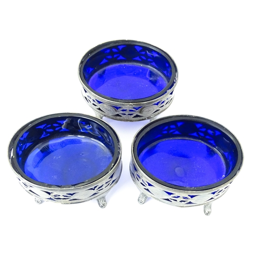 339 - A set of three George III silver salts of oval form with pierced decoration and blue glass liners, h... 