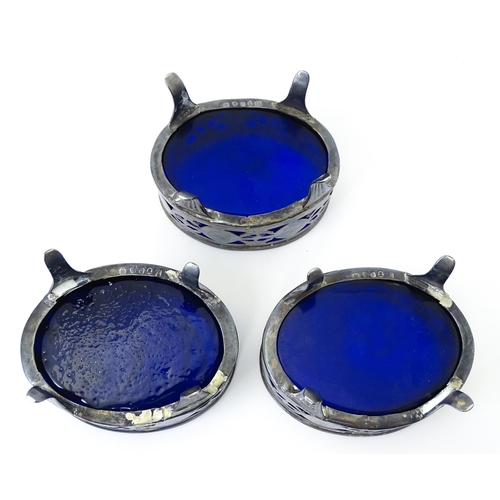 339 - A set of three George III silver salts of oval form with pierced decoration and blue glass liners, h... 