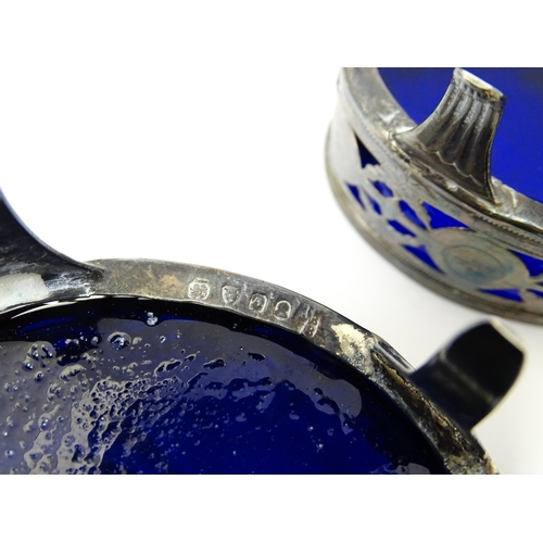 339 - A set of three George III silver salts of oval form with pierced decoration and blue glass liners, h... 