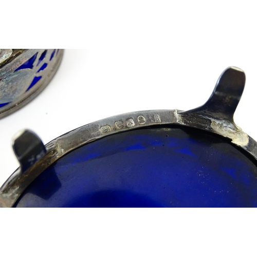 339 - A set of three George III silver salts of oval form with pierced decoration and blue glass liners, h... 