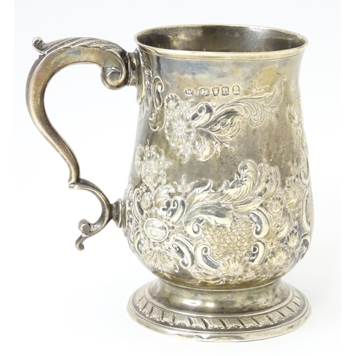 345 - A George III silver mug / tankard with repousse decoration, hallmarked London 1817. Approx. 5