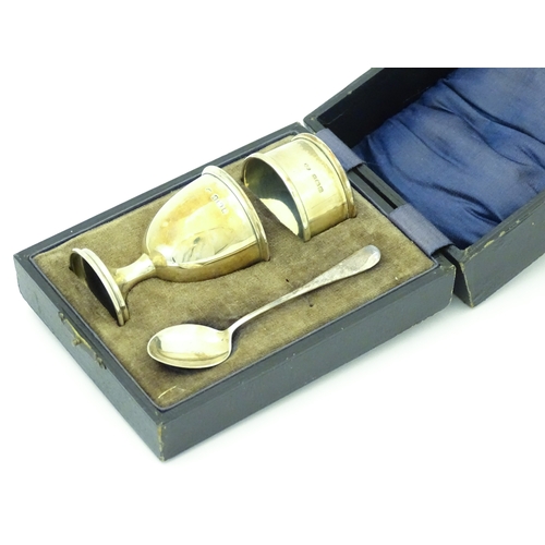 528 - A cased silver Christening set comprising egg cup, spoon and napkin ring, hallmarked Birmingham 1922... 