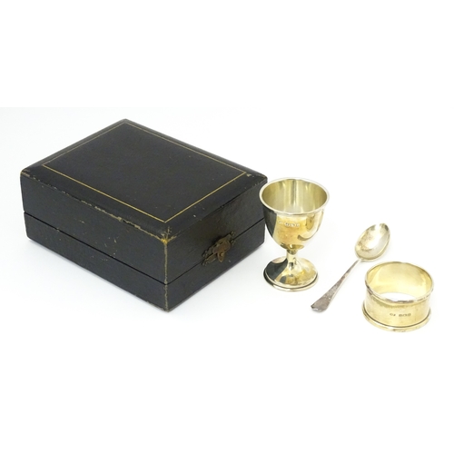 528 - A cased silver Christening set comprising egg cup, spoon and napkin ring, hallmarked Birmingham 1922... 