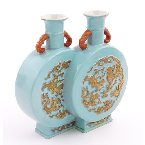 64 - A Chinese double moon vase with relief gilt detail. Character marks under. Approx. 6 1/2