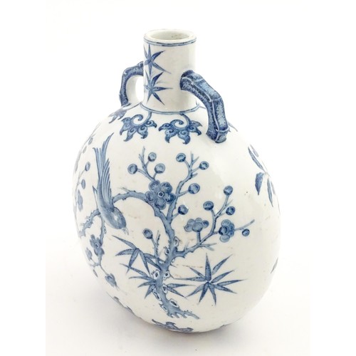 65 - A Chinese blue and white twin handled moon vase decorated with a bird perched on a branch. Approx. 9... 