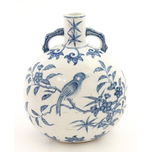65 - A Chinese blue and white twin handled moon vase decorated with a bird perched on a branch. Approx. 9... 