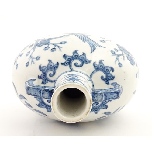 65 - A Chinese blue and white twin handled moon vase decorated with a bird perched on a branch. Approx. 9... 