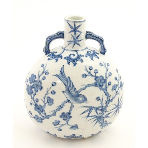 65 - A Chinese blue and white twin handled moon vase decorated with a bird perched on a branch. Approx. 9... 