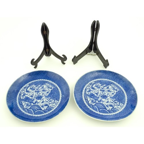 72 - A pair of Chinese blue and white chargers decorated with dragons and a flaming pearl amongst stylise... 