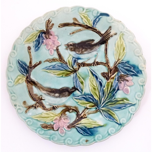 84 - A pair of French majolica plates with relief decoration depicting birds, berries and leaves. Approx.... 