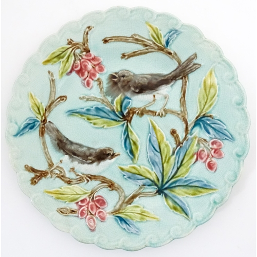 84 - A pair of French majolica plates with relief decoration depicting birds, berries and leaves. Approx.... 