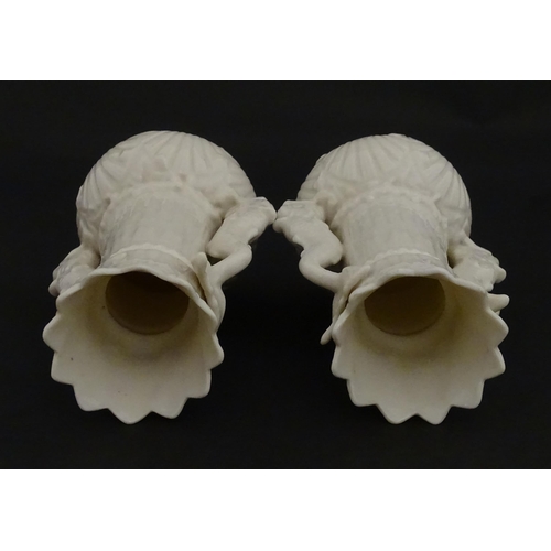 110 - A pair of Belleek dolphin spill vases with twin fish handles and shell detail to base. Marked with S... 