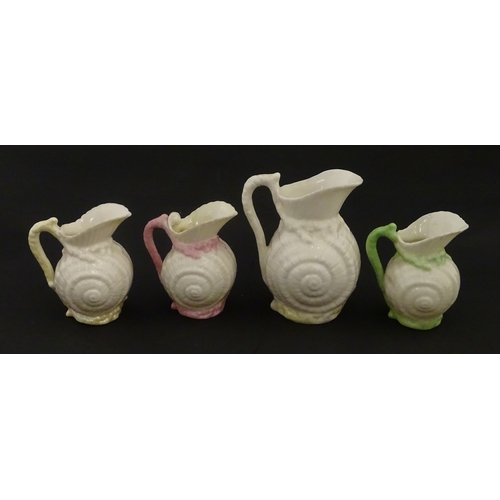 102 - Four Belleek Nautilus Shell creamers / milk jugs, to include three toy creamers with painted highlig... 