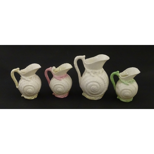 102 - Four Belleek Nautilus Shell creamers / milk jugs, to include three toy creamers with painted highlig... 