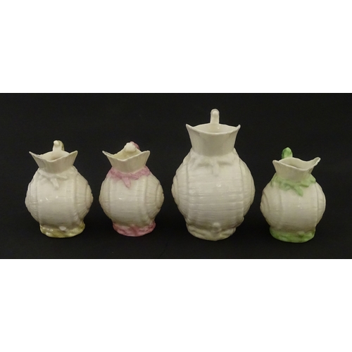 102 - Four Belleek Nautilus Shell creamers / milk jugs, to include three toy creamers with painted highlig... 