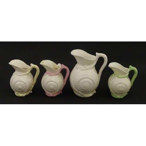 102 - Four Belleek Nautilus Shell creamers / milk jugs, to include three toy creamers with painted highlig... 