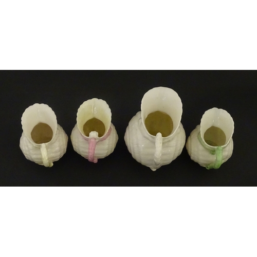 102 - Four Belleek Nautilus Shell creamers / milk jugs, to include three toy creamers with painted highlig... 