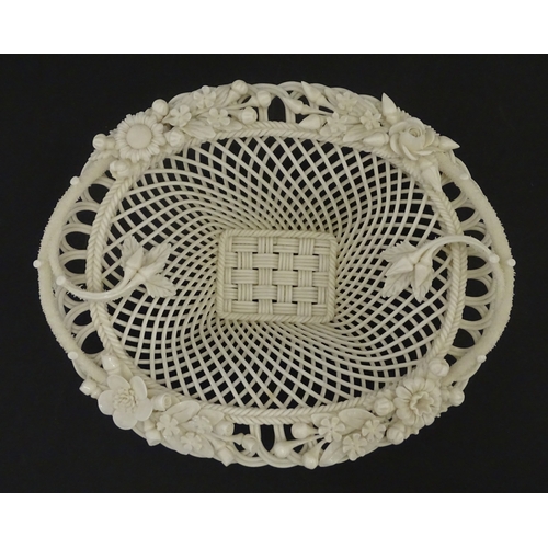 104 - A Belleek four strand basket of oval form with flower and foliate detail to rim. Bearing impressed m... 
