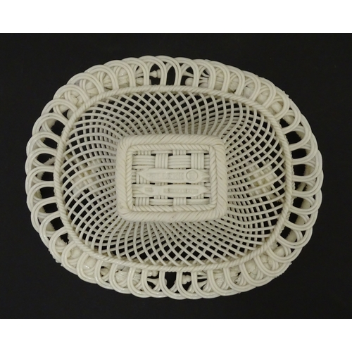 104 - A Belleek four strand basket of oval form with flower and foliate detail to rim. Bearing impressed m... 