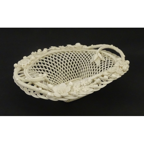 104 - A Belleek four strand basket of oval form with flower and foliate detail to rim. Bearing impressed m... 