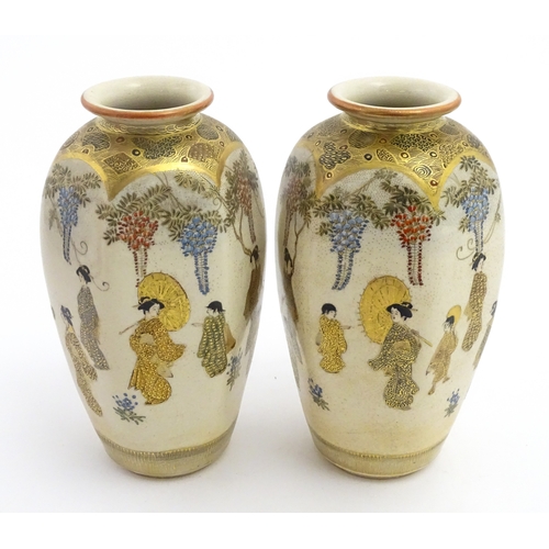 68 - A pair of Japanese Satsuma vases decorated with ladies and blooming wisteria. Character marks under.... 
