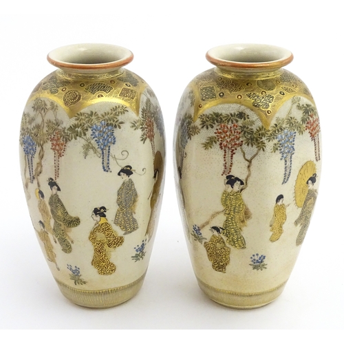 68 - A pair of Japanese Satsuma vases decorated with ladies and blooming wisteria. Character marks under.... 