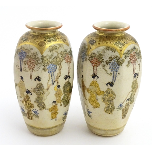 68 - A pair of Japanese Satsuma vases decorated with ladies and blooming wisteria. Character marks under.... 