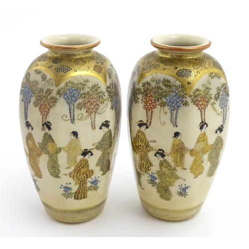 68 - A pair of Japanese Satsuma vases decorated with ladies and blooming wisteria. Character marks under.... 