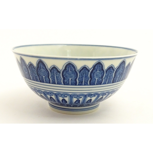 70 - A Chinese blue and white bowl decorated with banded foliate detail, and central flower motif. Charac... 