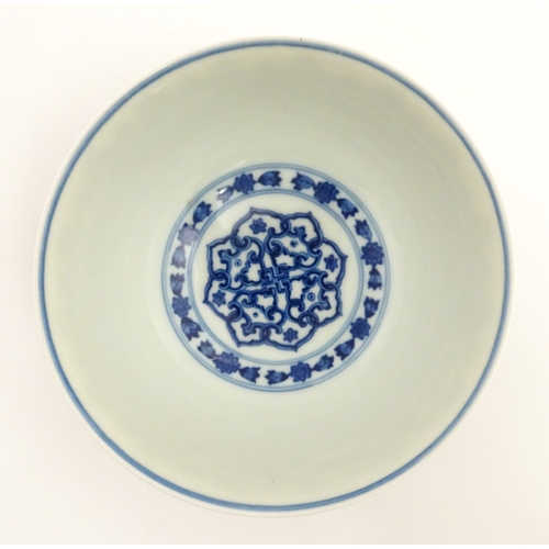 70 - A Chinese blue and white bowl decorated with banded foliate detail, and central flower motif. Charac... 