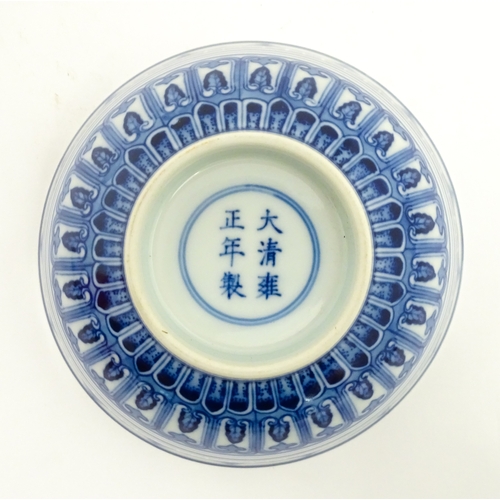 70 - A Chinese blue and white bowl decorated with banded foliate detail, and central flower motif. Charac... 