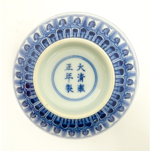 70 - A Chinese blue and white bowl decorated with banded foliate detail, and central flower motif. Charac... 