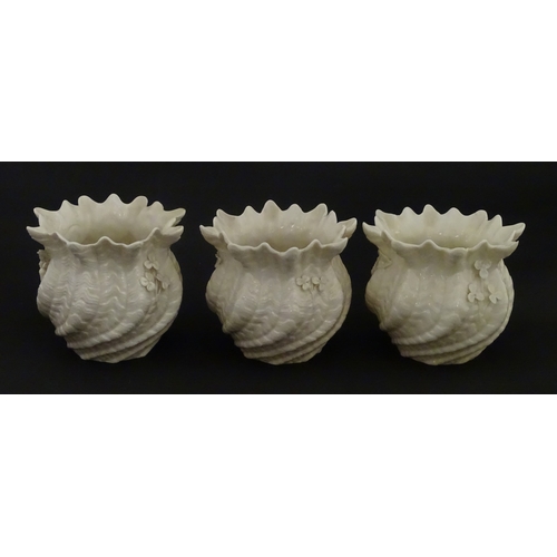 94 - Three small Belleek Neptune vases / jardinieres with applied flower and foliage decoration. Each bea... 