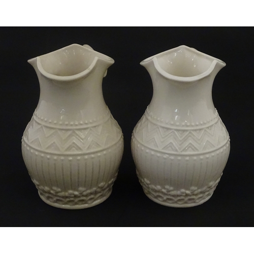 96 - A pair of Belleek Harp jugs / pitchers with banded decoration. Both bearing Second Period marks unde... 