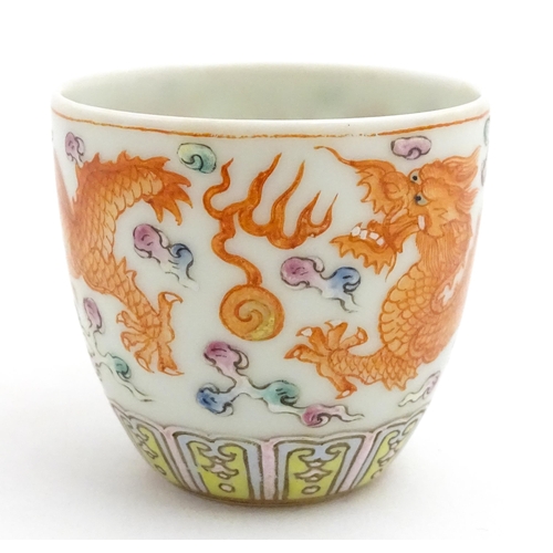65A - A small Chinese cup decorated with dragons and flaming pearl of wisdom detail. Character marks under... 