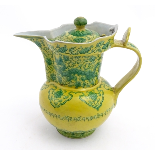 75 - A Chinese yellow ground wine ewer decorated with green dragons and lotus flowers. Character marks un... 
