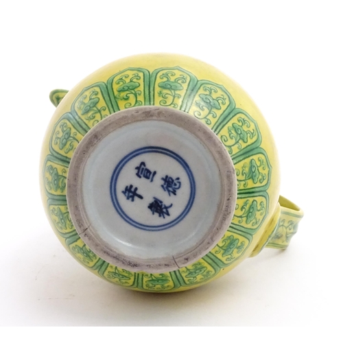 75 - A Chinese yellow ground wine ewer decorated with green dragons and lotus flowers. Character marks un... 