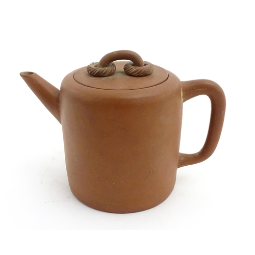 77 - A Chinese yixing teapot with rope detail to lid. Character marks under. Approx. 4 1/2