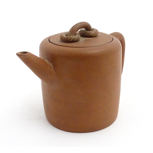 77 - A Chinese yixing teapot with rope detail to lid. Character marks under. Approx. 4 1/2