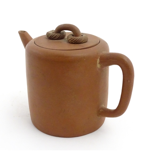 77 - A Chinese yixing teapot with rope detail to lid. Character marks under. Approx. 4 1/2