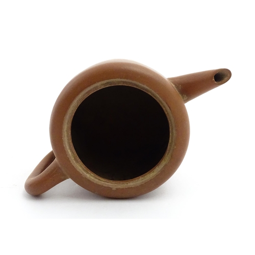 77 - A Chinese yixing teapot with rope detail to lid. Character marks under. Approx. 4 1/2