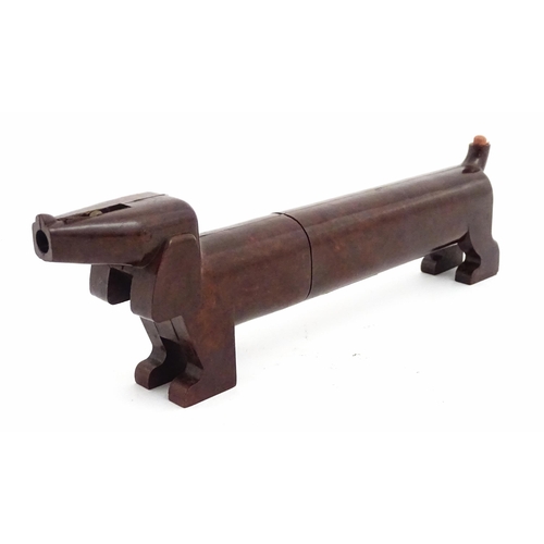 A vintage novelty Bakelite style stationery holder / pencil case modelled as a Dachshund / Sausage Dog by the Plastic Moulding Co, Ltd, with a pencil sharpener to head and eraser to tail. Marked under Reg. Daxy Design, British Made. Approx. 10" long