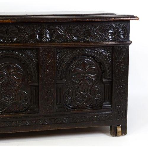 A 17thC oak coffer with a carved, panelled front and lozenge moulded ...