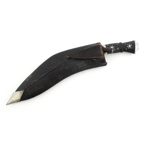 452 - A mid 20thC Indian Kukhri knife with carved horn handle. The leather scabbard with additional chakma... 