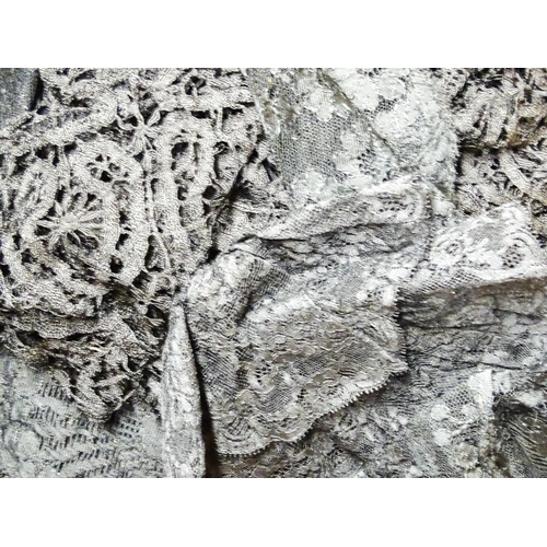 31 - A quantity of assorted textiles to include a 20thC needlework sample with letters of the alphabet by... 