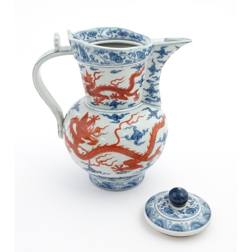 13 - A Chinese blue, white and iron red wine ewer decorated with dragons and stylised clouds. Character m... 