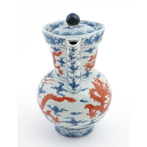 13 - A Chinese blue, white and iron red wine ewer decorated with dragons and stylised clouds. Character m... 