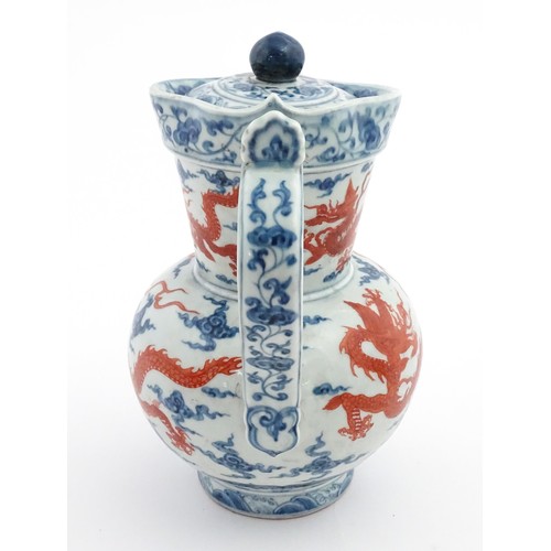 13 - A Chinese blue, white and iron red wine ewer decorated with dragons and stylised clouds. Character m... 