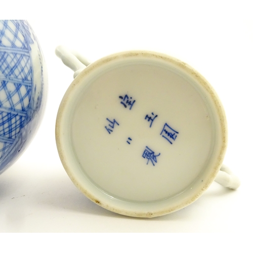 49 - A Chinese blue and white twin handled cup and cover decorated with cranes in flight with bamboo fini... 
