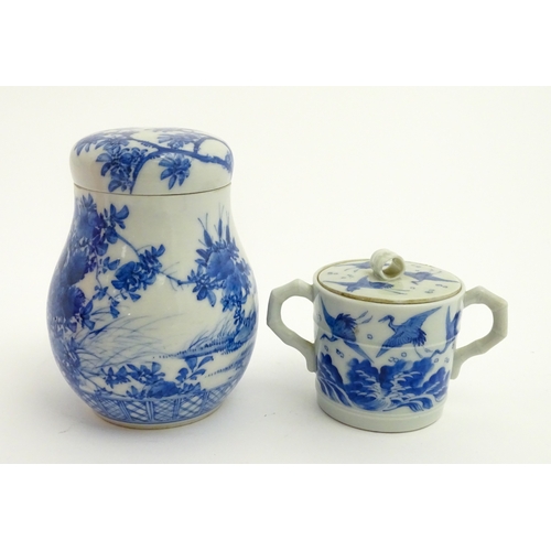 49 - A Chinese blue and white twin handled cup and cover decorated with cranes in flight with bamboo fini... 